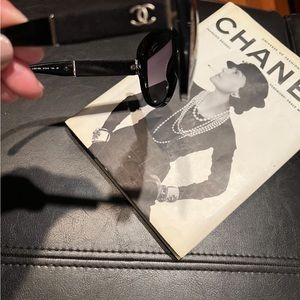 A pair of black Chanel sunglasses with case. Scratches at the end of temples.